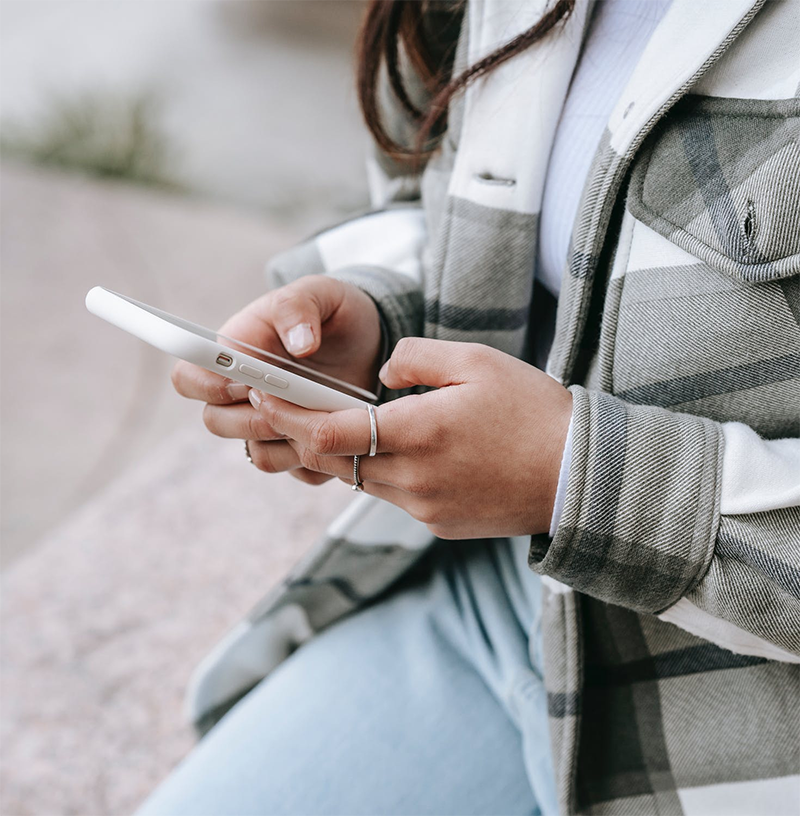 close up of woman in plaid jacket texting on cell phone
